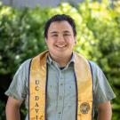 Chemical Engineering student Vincent Martin stands against a green and yellow bush backdrop